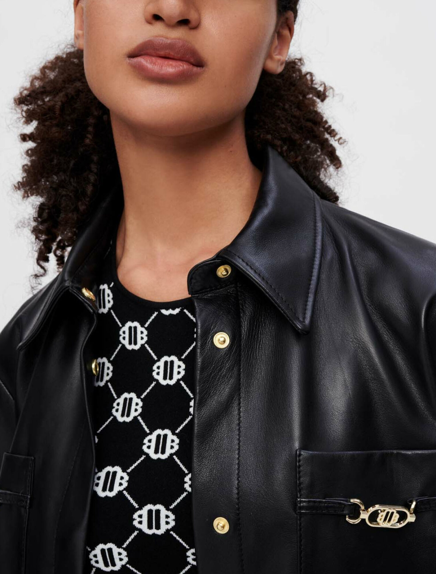 Camisa de piel negra con bocados dorados