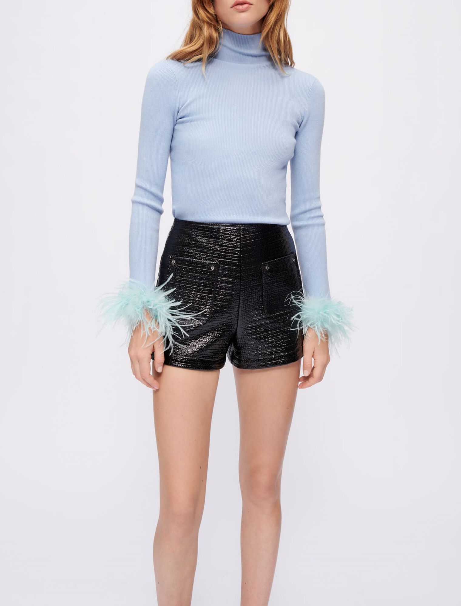 Jersey cuello vuelto y plumas en el puño
