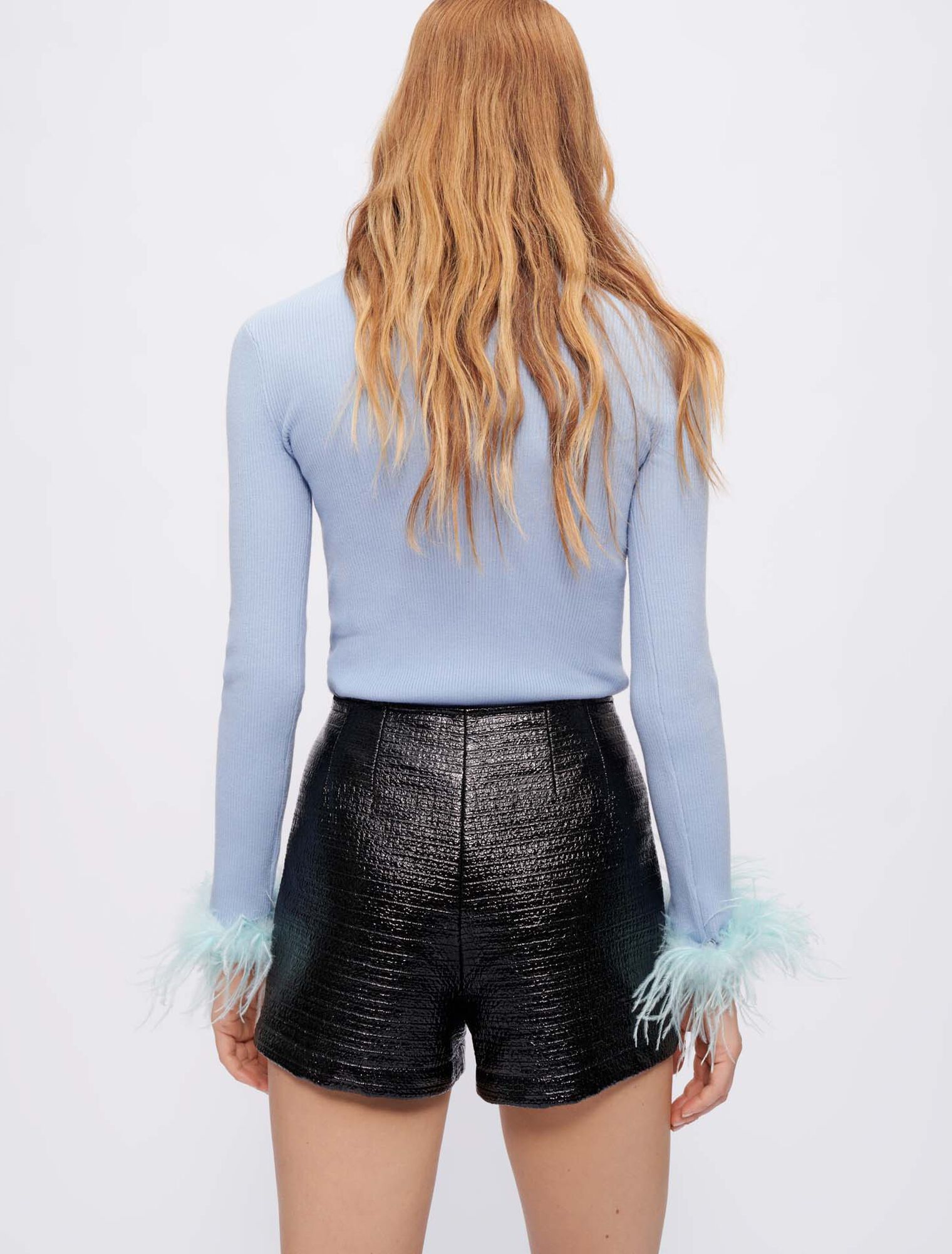 Jersey cuello vuelto y plumas en el puño