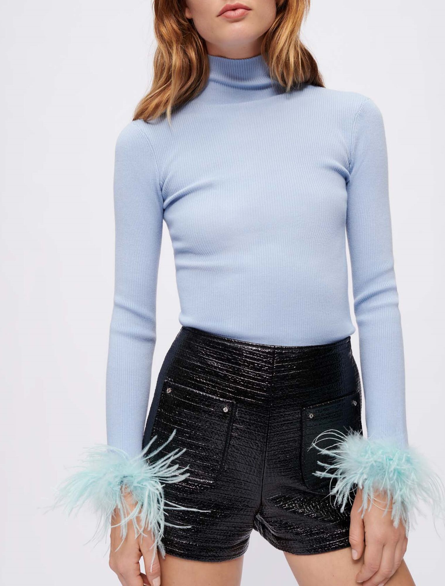 Jersey cuello vuelto y plumas en el puño