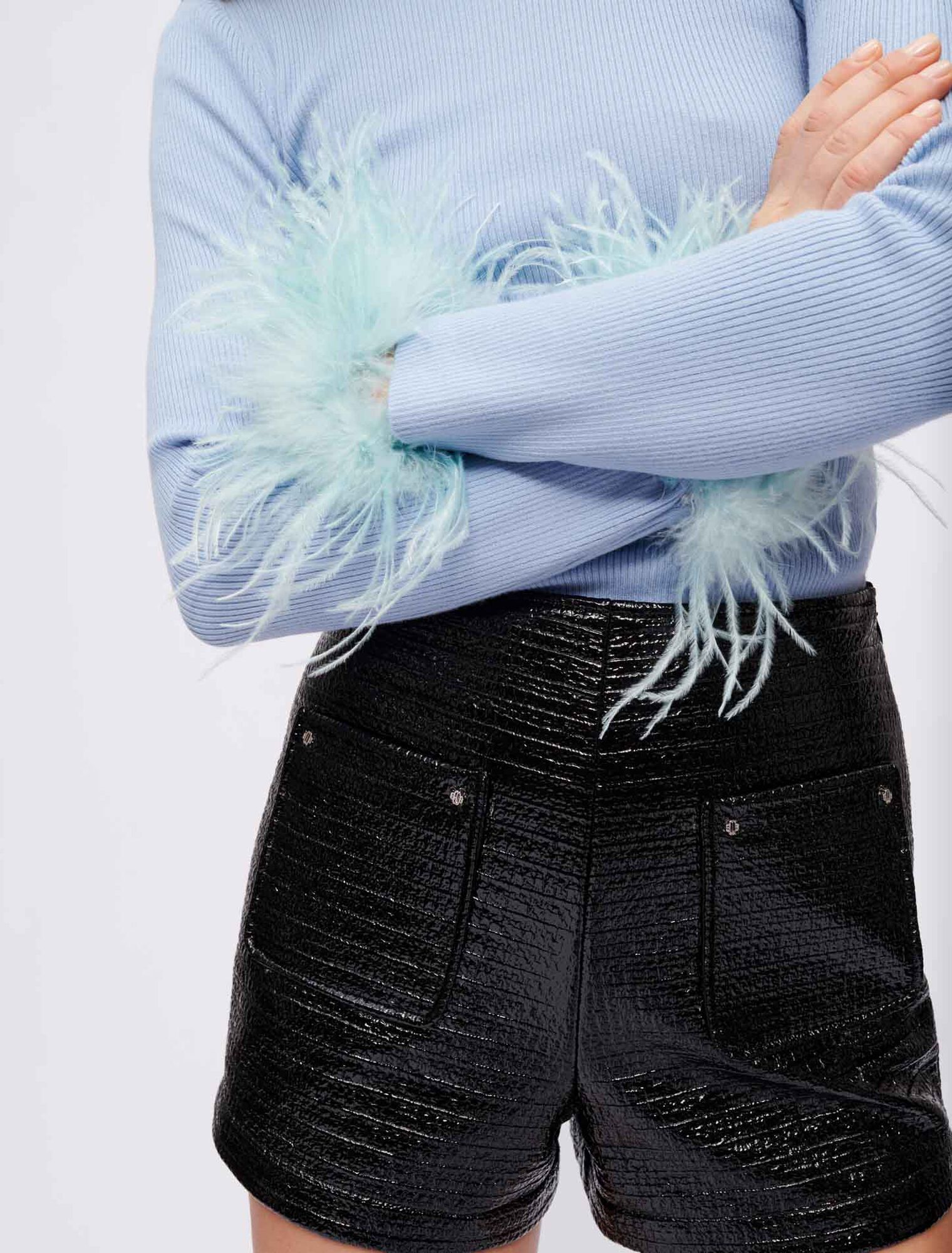 Jersey cuello vuelto y plumas en el puño